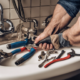 Cum să identificați și să reparați scurgerile de apă în bucătărie: Soluții eficiente pentru un mediu sigur. 6 793660 a plumber working with real tools xl 1024 v1 0